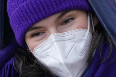 visage féminin avec un bonnet violet et un masque FFP2
